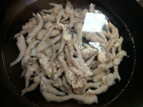 鸡爪冷水下锅焯水，水烧开后，再煮两三分钟，有时可以看到会有一些白沫出现。关火，将鸡爪捞出，自来水冲洗干净。