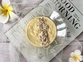 在芒果奶昔面上撒一道即食燕麦片；