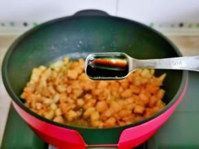 再加入一勺生抽，把鸡丁炒熟。