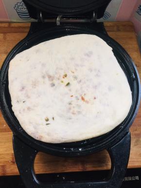 提前把电饼铛加热，倒上适量的油，放入饼胚！
