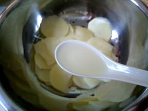 取一个大碗装土豆片，加1汤匙玉米油。