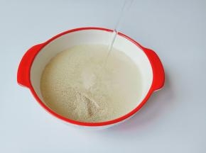 碗里放酵母粉，白砂糖加入清水255克。