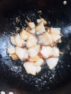 起锅烧热倒入熟猪肉煸炒至猪肉变色微卷，煸炒出多余的油脂！