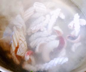 锅中烧开水放入鱿鱼快速焯水鱿鱼会立即成卷