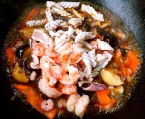 放入鱿鱼卷和去皮焯水后的虾仁大火快速翻炒均匀