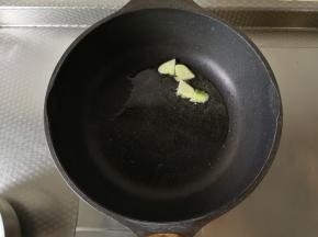 干净无水不粘锅中，倒入玉米油，开大火下姜片爆香。