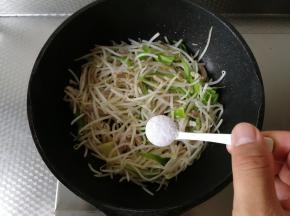 淋入料酒提味，炒匀后再加一点点清水，一起翻炒，这样炒出的豆芽略带汤汁，比较好吃！一起翻炒到豆芽完全变软。然后加盐，炒匀调味！