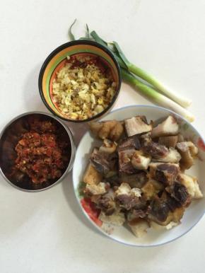 准备好所需的材料：腊猪蹄 煮熟切成块儿，辣椒黄豆酱一碟，蒜苗剥皮洗净切段，蒜瓣剁碎，生姜切成小丁，干辣椒切段备用！