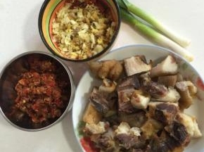 准备好所需的材料：腊猪蹄 煮熟切成块儿，辣椒黄豆酱一碟，蒜苗剥皮洗净切段，蒜瓣剁碎，生姜切成小丁，干辣椒切段备用！