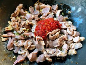 放入鸡胗同时放入蒜蓉辣椒酱和糖翻炒均匀