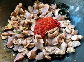 放入鸡胗同时放入蒜蓉辣椒酱和糖翻炒均匀