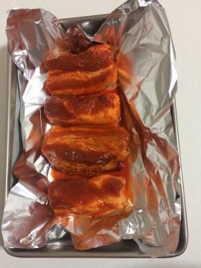 烤盘里铺上一层油纸，再垫上一层锡纸，把腌好的五花肉摆在烤盘里！有烤架的可以直接放在烤架上面烤！(一定记得烤盘里铺油纸和锡纸哦，这样烤盘里才不会弄脏，容易清洗！)


