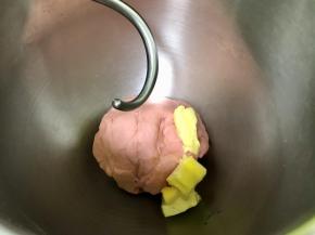 厨师机先开低速 2档揉至无干粉状态，再开高速 4档揉至可以抻出厚膜的状态，然后加入室温软化的黄油，继续开低速2档揉至黄油被吸收。
