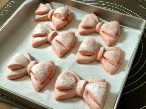 体积增大，蝴蝶结变厚，按下去会回弹的状态就可以了。在表面筛上高筋面粉。烤箱开始预热，上下管设置 180度。