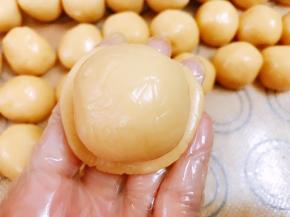 静置好的饼皮分为20份，取一份饼皮压扁包入一个莲蓉蛋黄