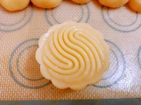 模具撒粉后倒出防粘，把做好的生坯略微搓成椭圆形放入模具里压出花纹