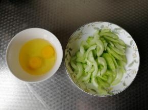 黄瓜去皮，清洗干净，切掉一点头尾，然后对半切开，去籽。虽然是嫩黄瓜，但是还是去籽，比较好吃！然后切薄片。鸡蛋2个打入干净碗里。