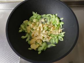 然后加入之前炒好的鸡蛋，一起翻炒一会。然后稍微加一点点清水，继续翻炒一会。