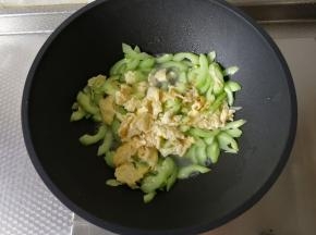 然后加入之前炒好的鸡蛋，一起翻炒一会。然后稍微加一点点清水，继续翻炒一会。