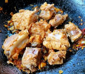 放入排骨炒至变色入味
