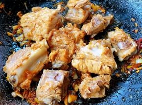 放入排骨炒至变色入味