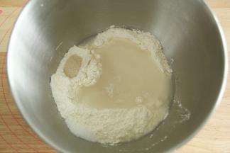 将高粉倒入打面桶（可以预先冷藏降温），盐和酵母分开放两个角落，然后倒入纯净水和蜂蜜。夏天注意控制面温，打好的面团温度在26度左右比较合适。