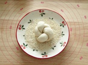 蘸过红糖水，接着蘸白芝麻（生、熟芝麻都可以，我用的白芝麻），动作轻柔一些。然后排入烤盘。