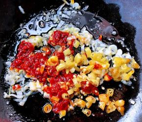 锅中放入底油加热放入葱姜蒜爆香再放入泡椒和红辣椒粒炒出辣味