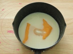 步骤3、不粘奶锅中，倒入牛奶，细砂糖，还有芝士片。