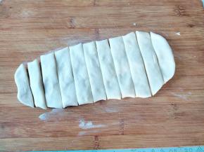 夏天温度高，面团回温个十几二十分钟就够了。将回温好的面团捏扁捏成一个厚的大面片，案板上撒一些玉米淀粉或面粉，将面片铺在案板上，用刀切成手指宽的一条条。