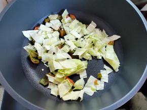 锅里倒入少量油，烧热，下辣椒和包菜，翻炒至断生。