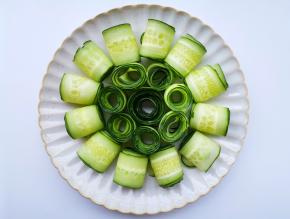 将黄瓜片从一头卷成卷码入盘中。