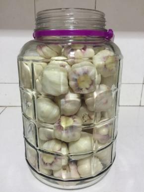 准备一个玻璃瓶，清洗干净，擦干水分，把晾干水分的蒜瓣放进去！




