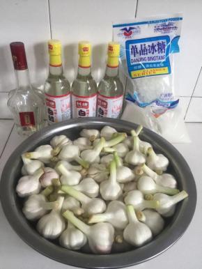 浸泡蒜瓣的时候，我们可以来准备腌制水晶糖蒜所需要的配料：白米醋3瓶，冰糖300克，白糖500克，白酒5滴！



