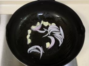 继续倒入少许油，加入蒜瓣爆香，下入洋葱翻炒。