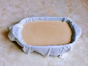 器具中垫好油纸，再倒入红糖奶糊。