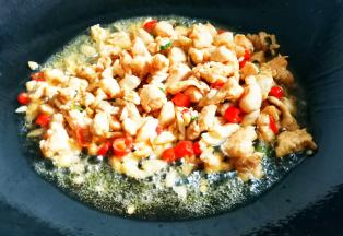 加入鸡胸肉丁，炒至变白，