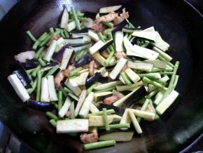 将豆角和茄子倒入，煸炒一会。炒到豆角颜色变深。