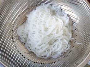 煮好的粉丝过自来水冲洗降温，然后晾干水。这里最好将粉丝剪断一下，不然太长一大团不好炒。