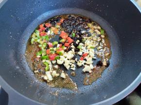 就用锅里剩余的油煎一下姜、蒜、辣椒和豆豉。如果锅里剩的油还很多，就倒出来一些，留点底油就可以了。