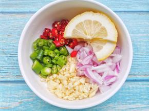 洋葱切碎，蒜切沫，青椒、小米椒切圈，柠檬切片全部放入大碗中，