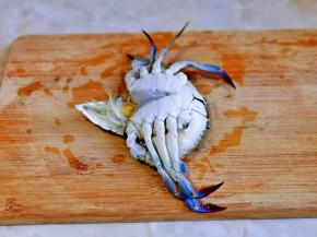 梭子蟹洗干净后，先把后面的三角形掰开，如图所示。