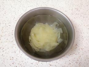 加入没过面皮的开水，盖上盖子泡5分钟左右，将红油面皮里面的酱料包放在盖子上一起加热一下。