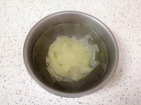 加入没过面皮的开水，盖上盖子泡5分钟左右，将红油面皮里面的酱料包放在盖子上一起加热一下。