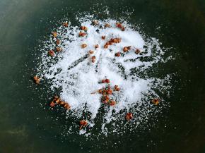 锅内放入食盐、花椒粒，小火翻炒。