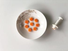 胡萝卜切成薄片，用花型模具切出小花的形状。