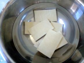 取一个大碗，装半碗水，加1勺盐融化，豆干泡半小时，一是去豆腥味，二是先入一下味。因为今天的豆干是薄的，所以没有煮。建议都用盐水煮几分钟。