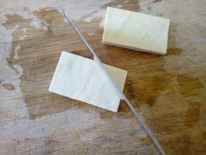 将豆干切成两块，然后正反两面各划三刀，千万不要切断了。