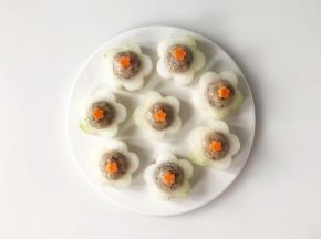 在虾滑中间放上压好的小花胡萝卜片。