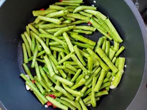 下豆角，继续煸炒至豆角变色。